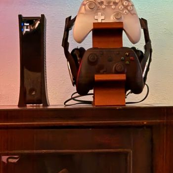 black 3-in-1 PS5 and Xbox Controller Stand – Compatible with PlayStation 5/Xbox Consoles. A gaming desktop organizer with a headphone hanger, non-charging base that holds 2 controllers and headphones. Space-saving white/black console accessory.